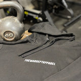 Black hoodie with 'THE WARDEPTAPPAREL' logo on a gym floor with kettlebell
